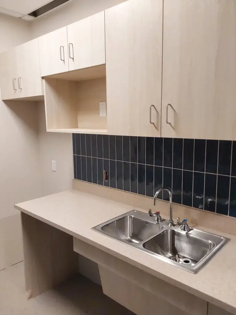 Breakroom cabinets with sink and microwave cubby.