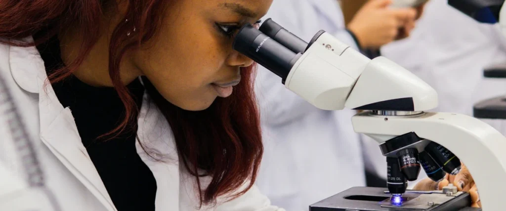 Scientist working at a microscope in a research laboratory