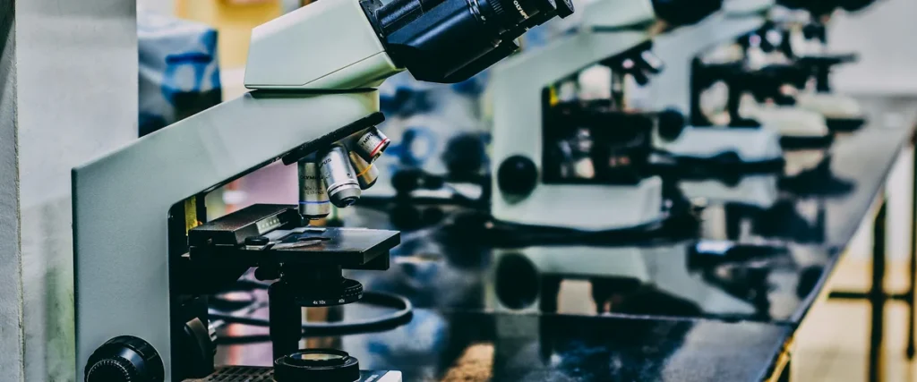 Row of microscopes on a black phenolic lab countertop | OnePointe Solutions